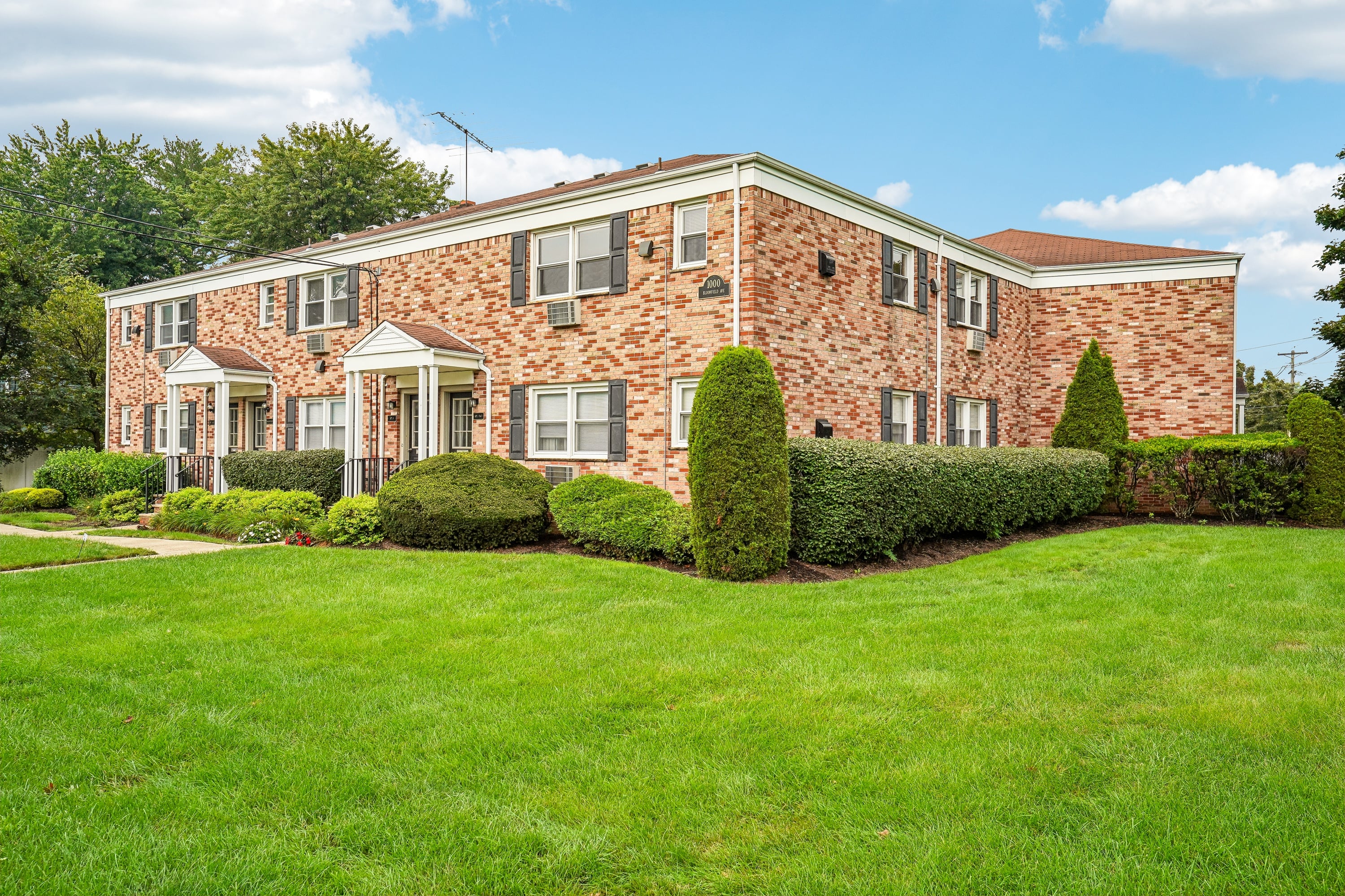 A brick house with a green lawn in front.